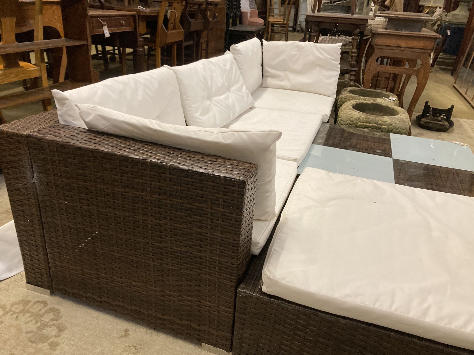 A rattan garden sofa, foot stool and glass top table, sofa width 210cm depth 70cm height 54cm